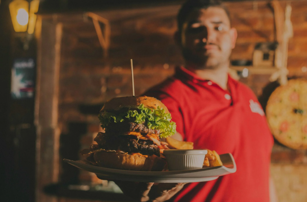 Waiter offer the giant burger in the restaurant