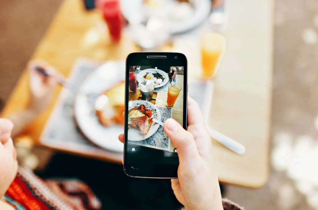 A woman clicking a photo from her cellphone